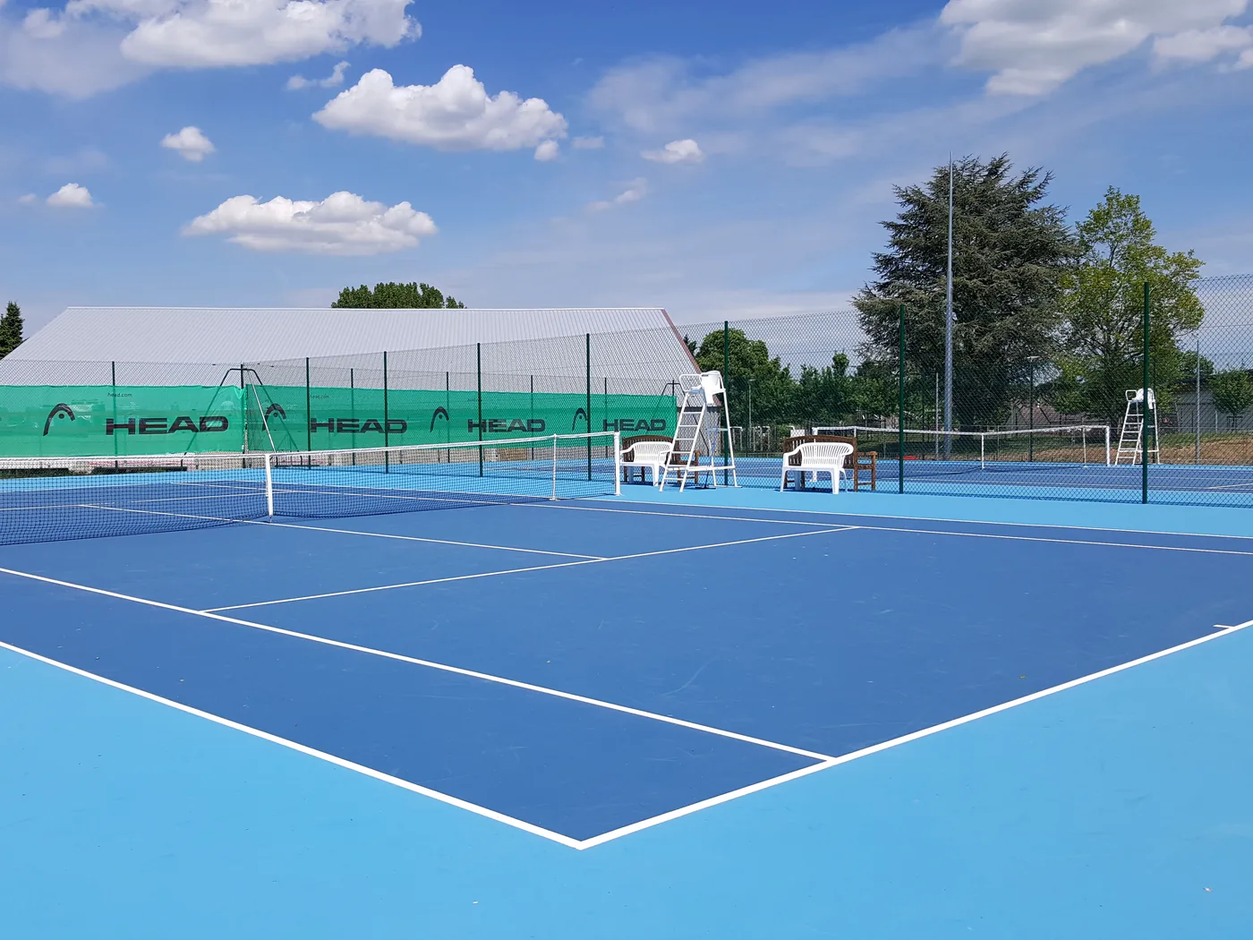 Court de tennis neuf en résine bleue, réalisé par TennisCourts