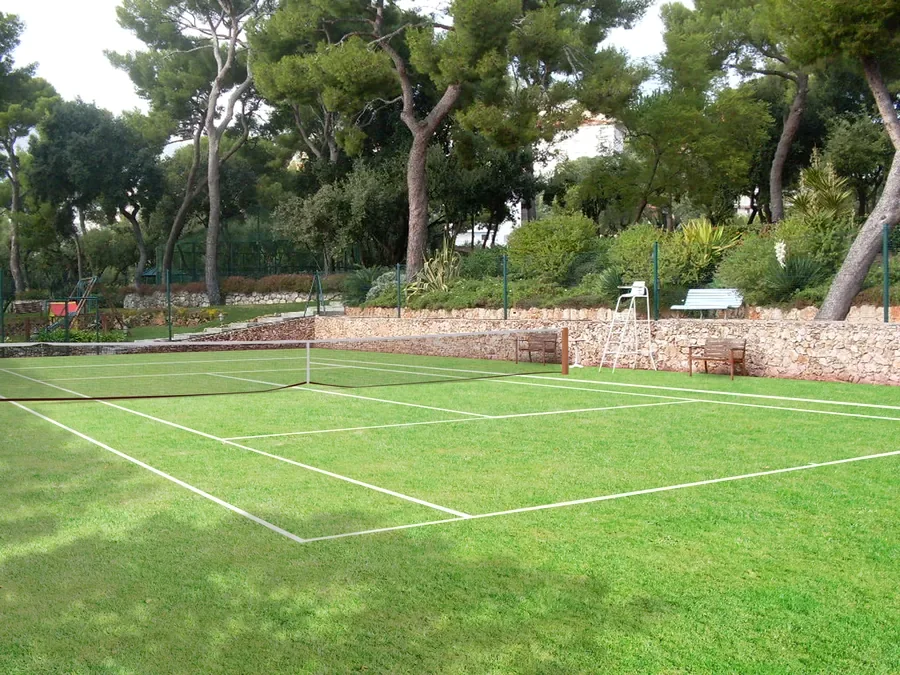 Court de tennis en gazon naturel bordé de murets en pierre